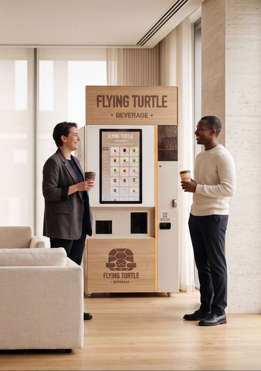 Two people talking over coffee next to a Flying Turtle machine in a bright lounge